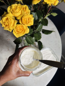 Cierra holding the L. Reuteri yogurt in front of a beautiful yellow bouquet. 